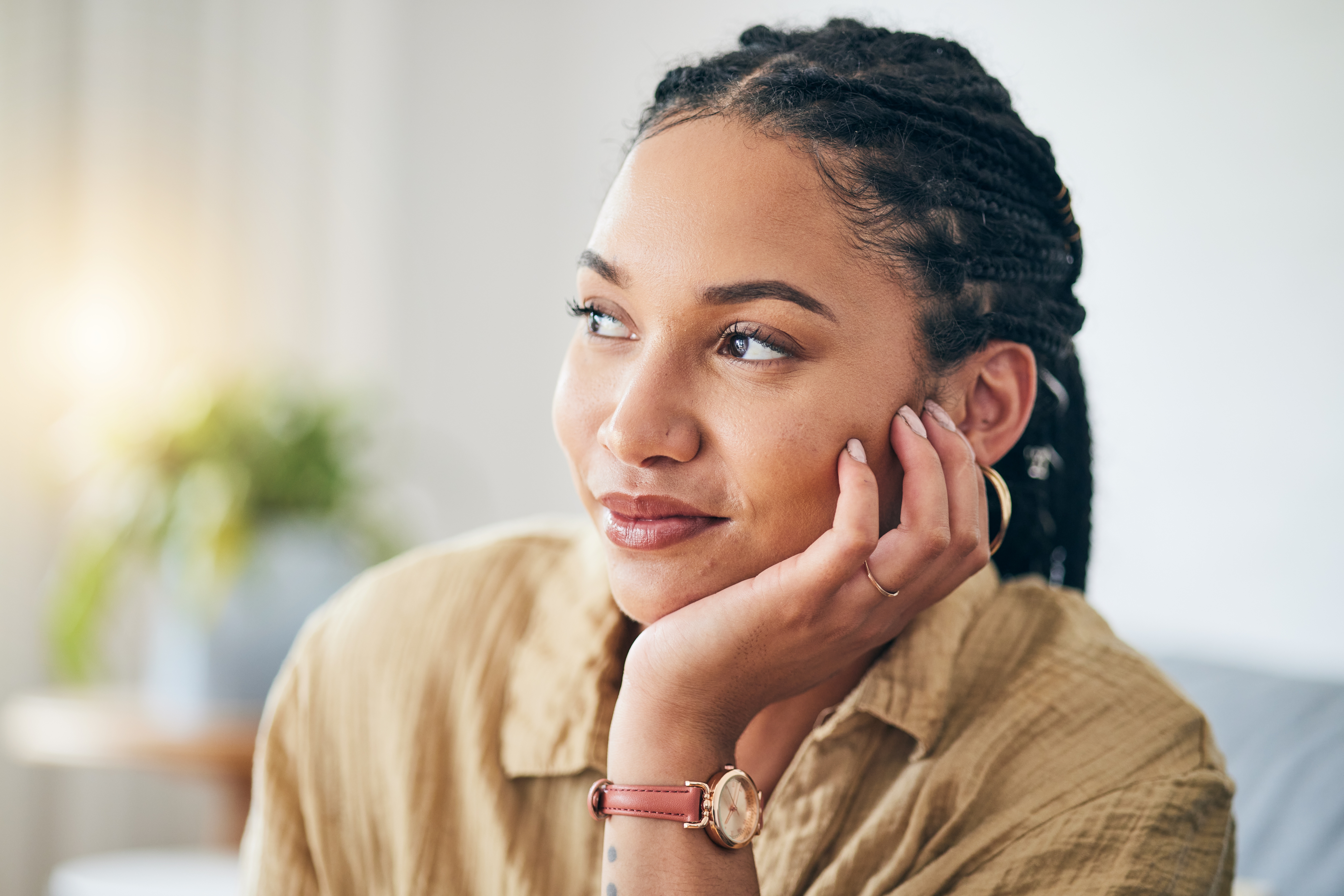 A woman with a calm expression rests her chin on her hand, reflecting peacefully. The image represents overcoming anxiety and finding mental wellness.